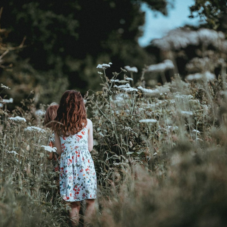 Girl walking among cow parsley