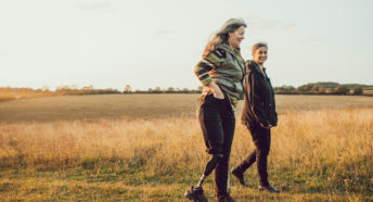 Two women walking in a field on a summer evening